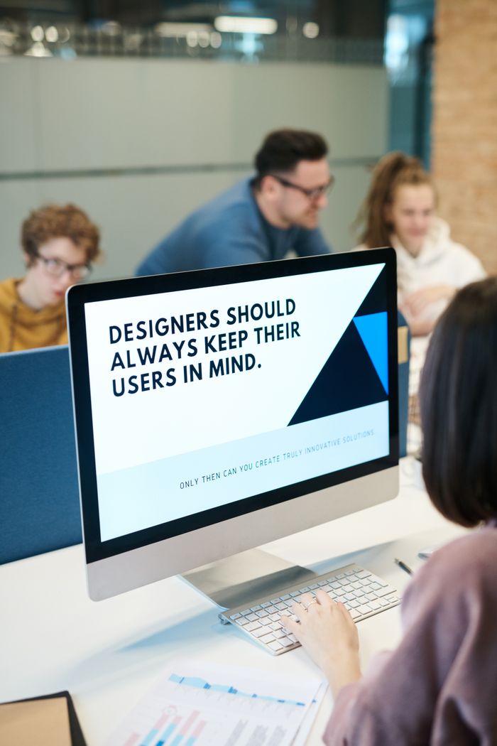 about-01 A team of designers working together in a contemporary office with a computer.
